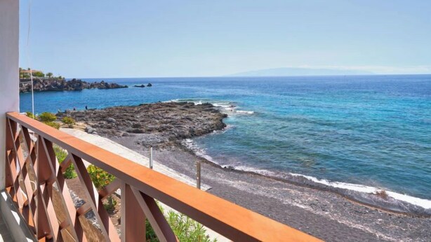 Un balcone con vista sull'oceano e sulla costa rocciosa.