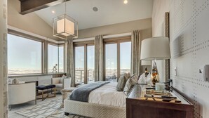 A bedroom with a large bed, a desk, and a view of the beach. - Four Bedroom Penthouse 4 Apartment Hotel by RedAwning (Park City)