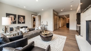 A modern living room with a sofa set, a coffee table, and artwork on the walls. - Premium Junior Three Bedroom 3 Apartment Hotel by Redawning (Park City)