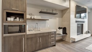 A modern kitchen with built-in appliances, wooden cabinets, and a large window. - Premium Junior Three Bedroom 3 Apartment Hotel by Redawning (Park City)