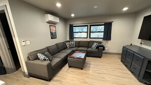 Een moderne woonkamer met een hoekbank, een salontafel en een tv-meubel.