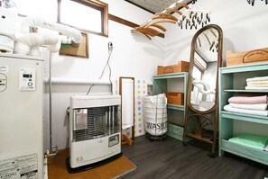A laundry room with a washing machine, dryer, and shelves with towels. - Pet friendly private lodge OMOTENASHI LODGE　YOUYOU (空知郡上富良野町)