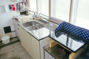 A compact kitchen with a sink, countertop, and a window providing natural light. - Pet friendly private lodge OMOTENASHI LODGE　YOUYOU (空知郡上富良野町)
