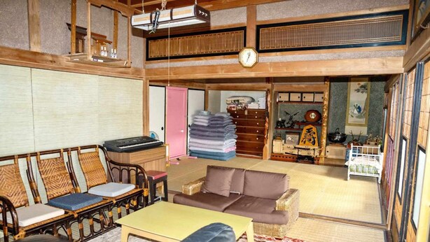 Perinteinen japanilaistyylinen huone, jossa on tatamimatto lattiana, matala puukatto ja tatamimatosta tehty sohva.