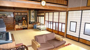 Perinteinen japanilainen huone, jossa on tatamimatto lattiana, tatamimatosta tehty sohva, piano ja vauvansänky.