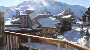 A snow-covered building with a wooden facade and multiple levels, surrounded by snow-covered mountains. - Rental Apartment 2 room 26 M2 - Alps - Avoriaz - Douchka - Falaise (Morzine)
