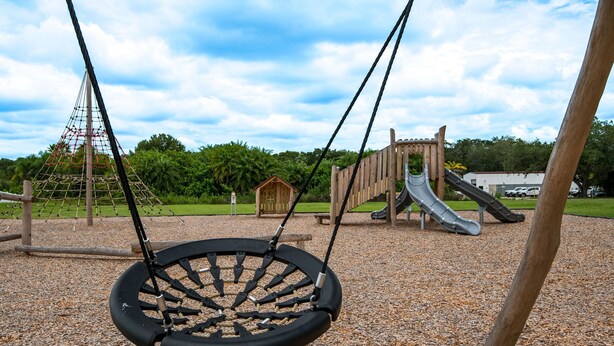 A playground with a swing set, a slide, and a climbing structure. - HS#1- Modern Studio next to Premier Sports Complex (Bradenton)