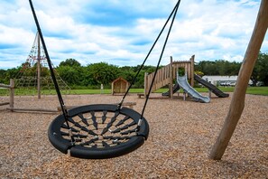 Ein Spielplatz mit Schaukel, Rutsche und Klettergerüst.
