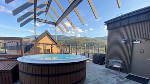 Ein Whirlpool auf einer Dachterrasse mit Blick auf die Berge.