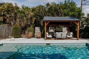 A swimming pool with lounge chairs and a gazebo. - THE PALMIERI luxe home with incredible pool area near DT SRQ (Sarasota)