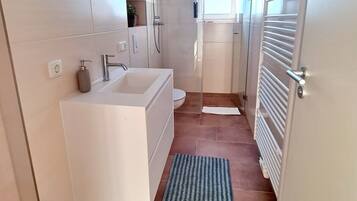 Een douche, een haardroger, handdoeken, shampoo