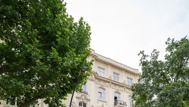 Ein mehrstöckiges Gebäude mit klassischer Architektur, mit aufwendigen Balkonen und großen Fenstern.