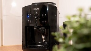 Eine Krups Kaffeemaschine mit digitaler Anzeige, Bedienfeld und Wasserbehälter.