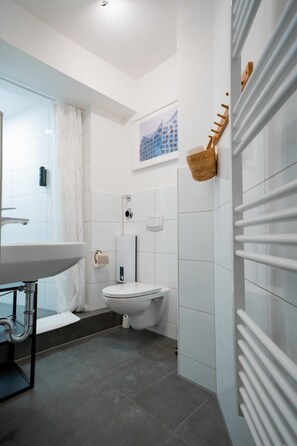 Chuveiro, secador de cabelo, toalhas de banho, shampoo