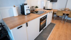 Une cuisine compacte équipée d’une machine à café, d’un grille-pain et d’un four.