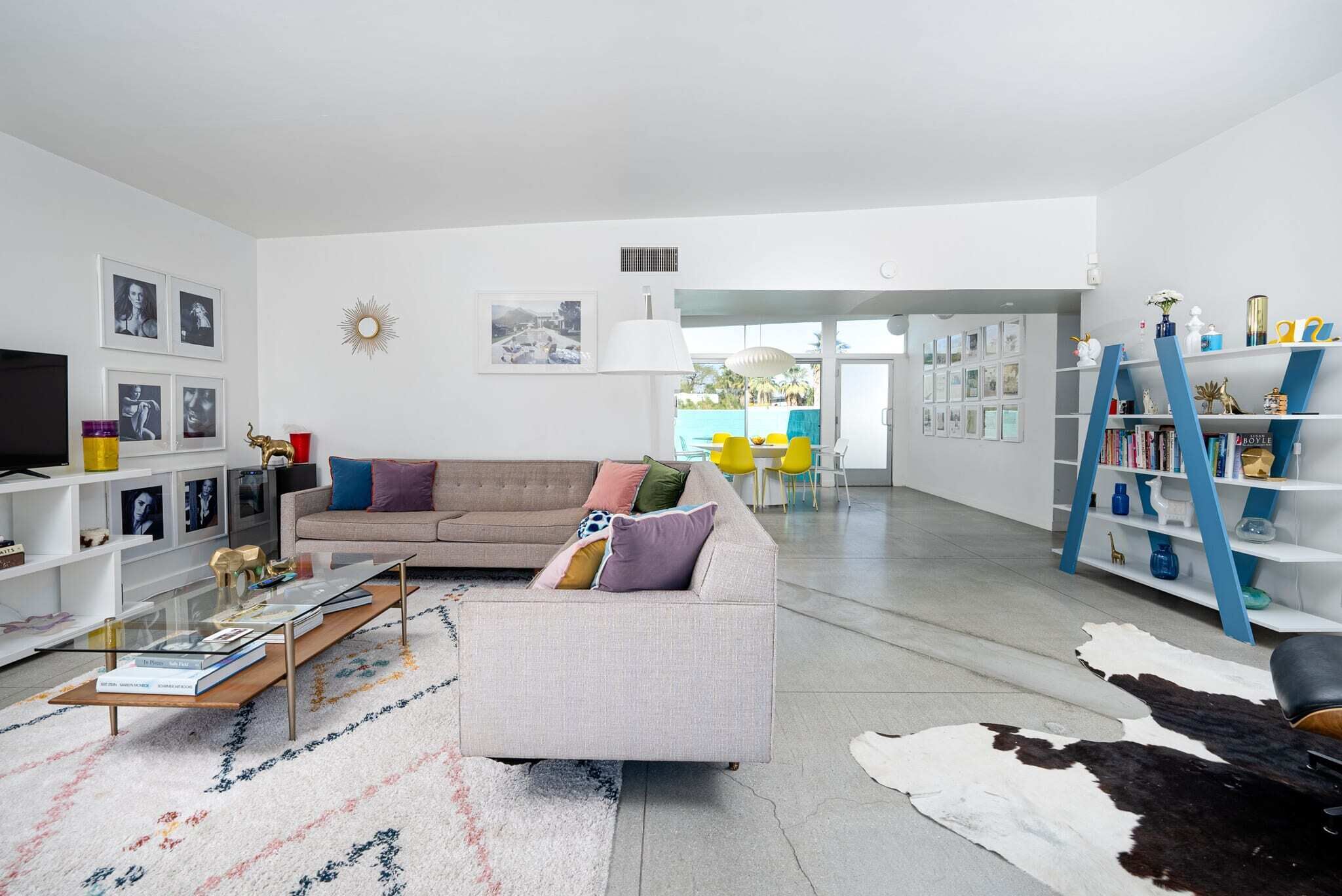 A modern living room with a sofa, coffee table, and a bookshelf.