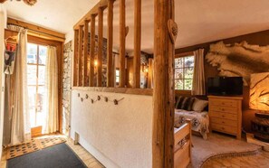 Step up to the upper level and unwind in this inviting room, featuring a comfortable bed, a fireplace, and a TV for entertainment.