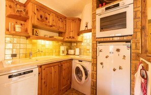 Compact kitchen with wooden cabinetry, tiled backsplash, and essential appliances.