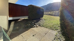 Une maison entourée d’une clôture en bois, avec un chemin de pierres et une pelouse bien entretenue.