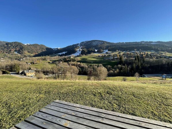 A scenic view of a vineyard with a wooden deck in the foreground.