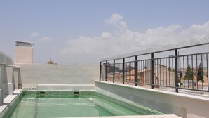 A rooftop swimming pool with a clear view of the surrounding buildings and sky. - Penthouse Lorena Apartment (Granada)