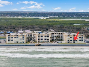 Un hôtel situé en bord de mer, avec plusieurs étages, une piscine et une vue sur l’océan.