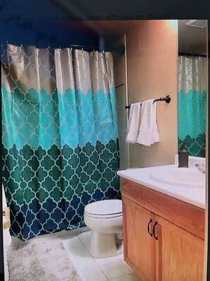 Een bad/douchecombinatie, een haardroger