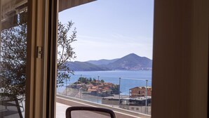 A balcony with a view of the sea and mountains, a chair, and a table. - Vertmont Villa (Sveti Stefan)