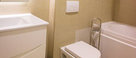 A bathroom with a toilet, sink, and bathtub.