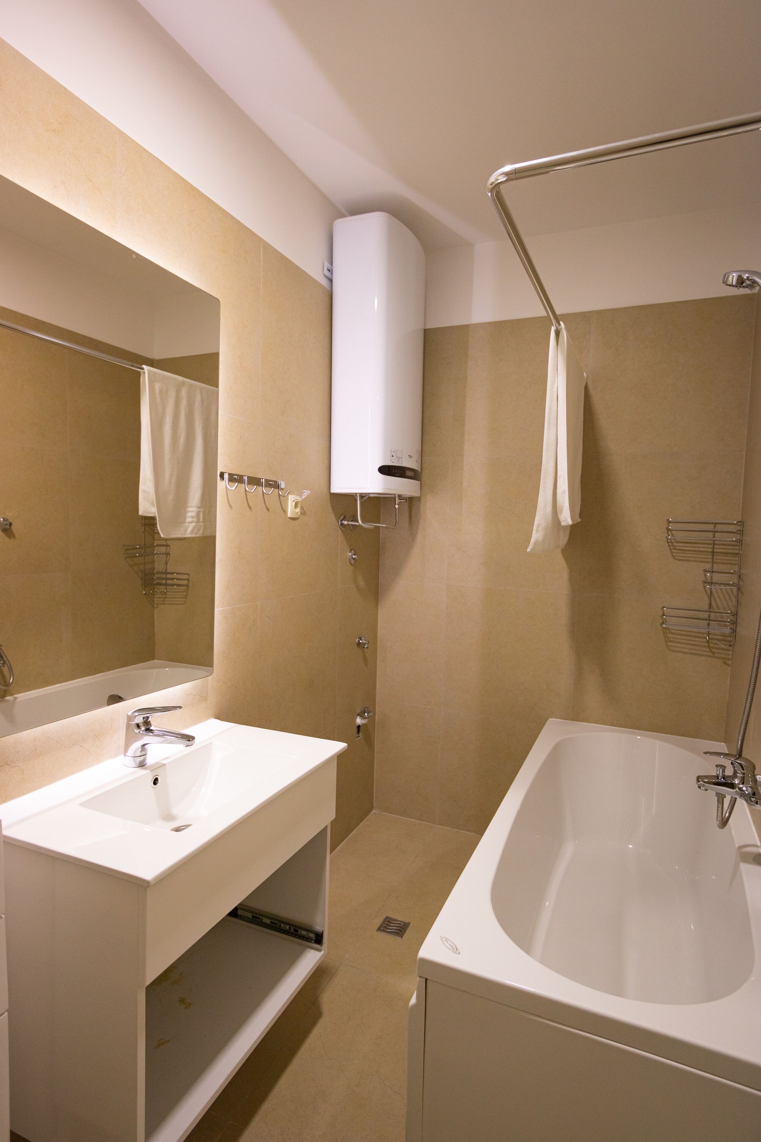 A modern bathroom with a bathtub, a sink, and a mirror.