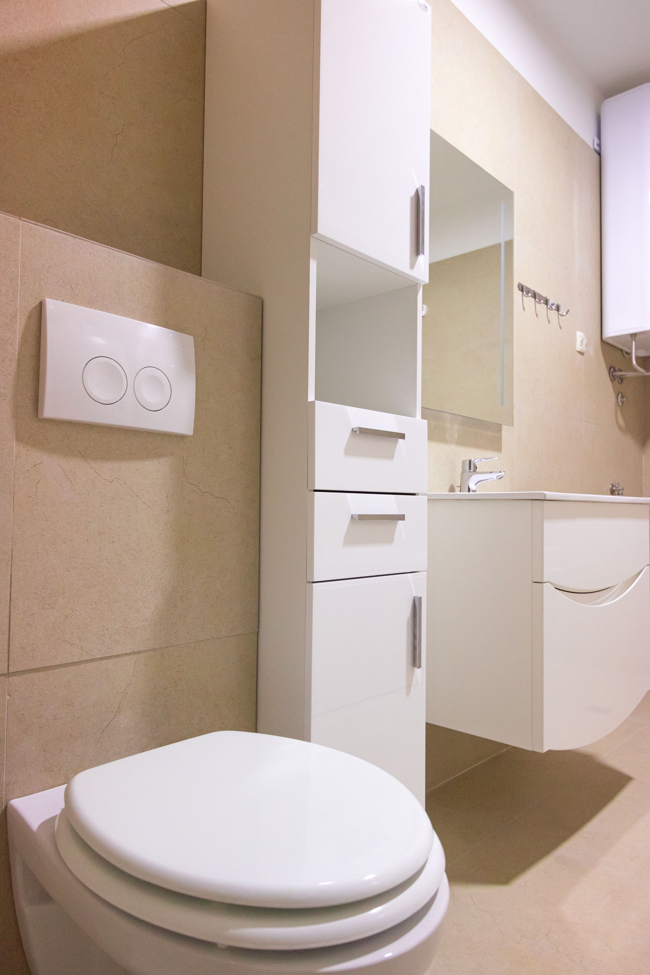 A modern bathroom with a toilet, a sink, and a mirror.