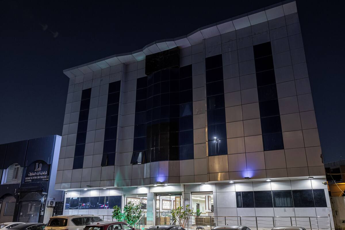 A modern building with a flat facade, large windows, and a well-lit entrance.