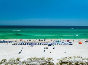 A beach with white sand and clear turquoise water.
