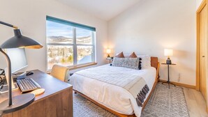A bedroom with a bed, desk, computer, and two bedside lamps. - Riverside mountain getaway, million dollar views, ground access, attached garage (Silverthorne)