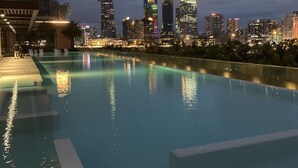 Una piscina con el horizonte de la ciudad al fondo.