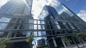 Un moderno edificio de vidrio con cielo despejado y nubes.