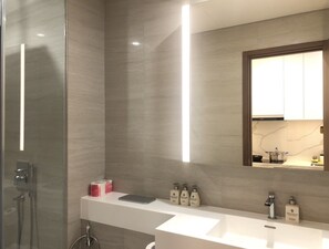 Une salle de bain moderne avec un grand miroir, un lavabo blanc et un espace douche.