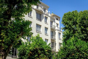 A multi-story building with balconies, surrounded by lush greenery and trees. - Alhambra Luxviews Apartment (Granada)
