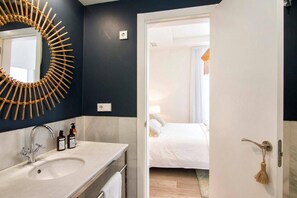 A hotel bathroom with a modern sink, mirror, and toiletries. - Alhambra Luxviews Apartment (Granada)