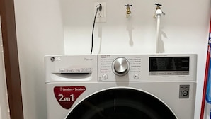 A front-loading LG washer with a 10-year warranty, a 2kg capacity, and a 'Lavado + Secadora' label. - New & beautiful apartment (GF) with private pool (Mérida)