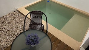 A small outdoor hot tub with a wooden deck and a chair. - New & beautiful apartment (GF) with private pool (Mérida)
