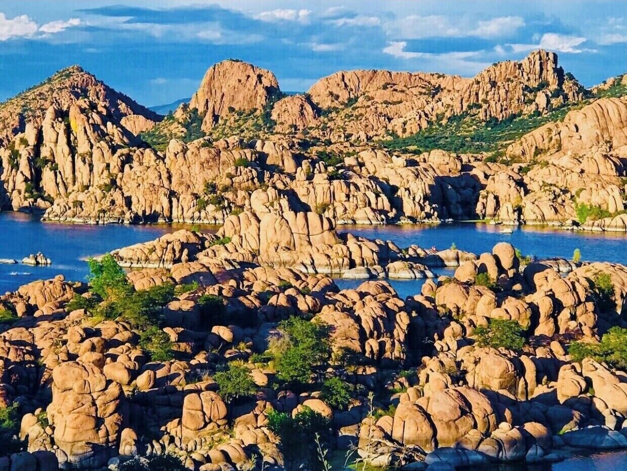 Un paisaje rocoso con grandes rocas y una masa de agua.
