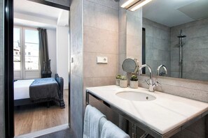 Een moderne badkamer met een grote spiegel, een wastafel en een douche.