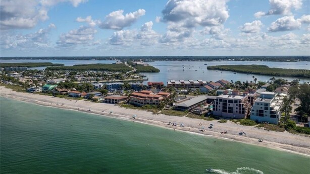 An aerial view of a coastal town with beachfront properties, a marina, and a clear sky. - Sunshine Swimmers Casita, 206 (Englewood)