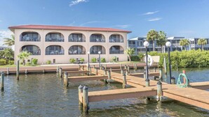 A waterfront hotel with a multi-story structure, outdoor seating, and a dock area. - Sunshine Swimmers Casita, 206 (Englewood)