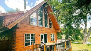 A log cabin with a deck, large windows, and a chimney. - Boutique All Wood Cottage in the Woods (Lanark)