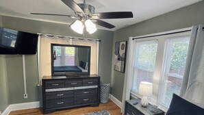 A bedroom with a bed, dresser, vanity, and a ceiling fan. - Downstairs Unit near National Park + Downtown Cleveland (Cleveland)