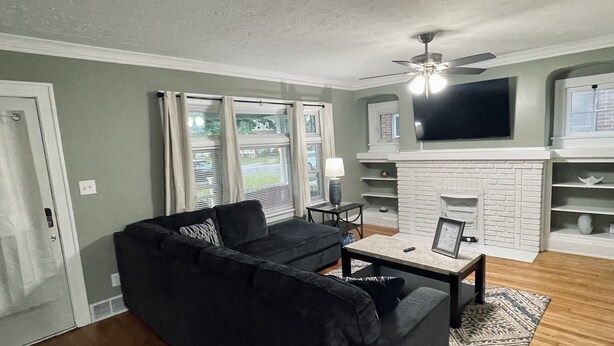 A living room with a sectional sofa, a coffee table, and a fireplace. - Downstairs Unit near National Park + Downtown Cleveland (Cleveland)