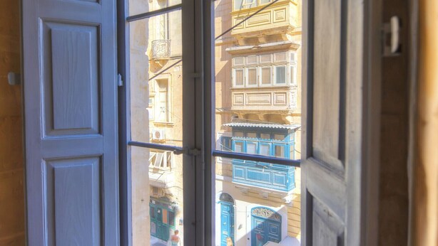 Ein Zimmer mit Fensterblick auf eine Straße.