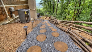 A stone pathway with wooden steps leading to a wooden cabin in a forested area. - Romantic and Cozy! 2 Bed 2 Bath True Log Cabin close to Park and Attractions!  (Gatlinburg)